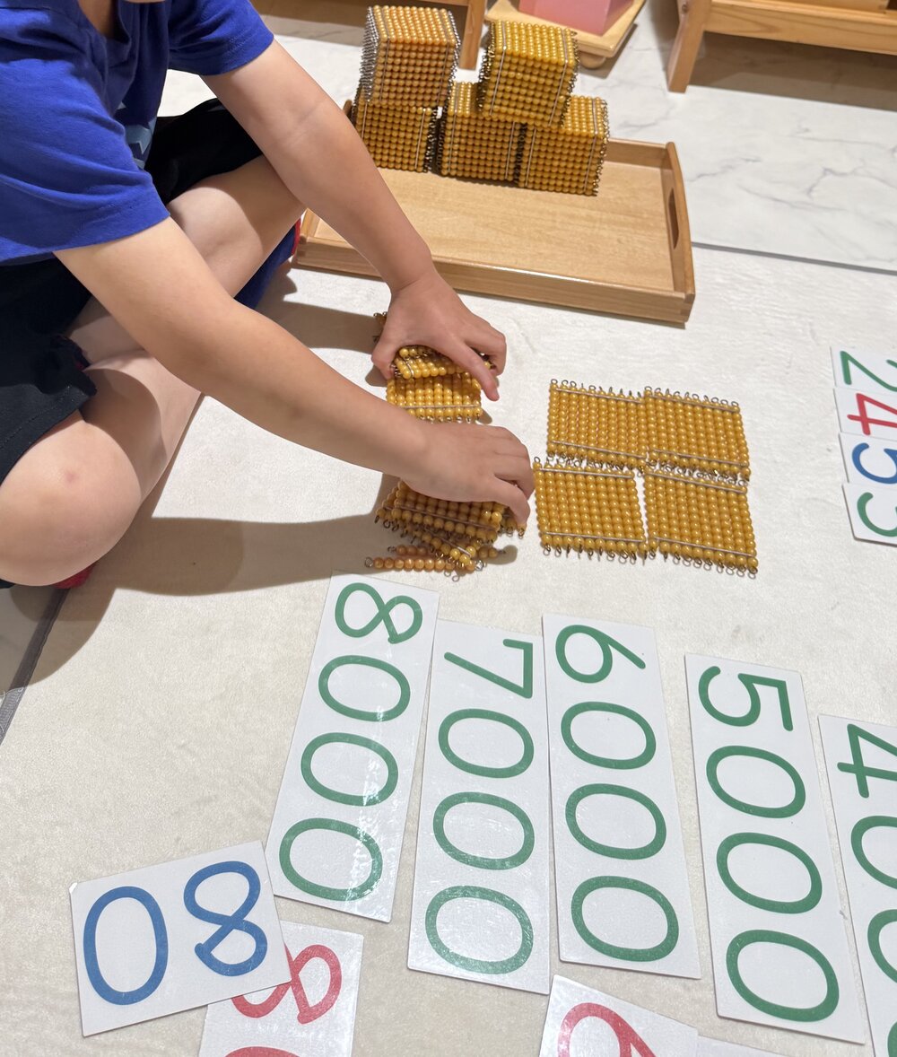 黄金ビーズの百のシートで学ぶ子ども